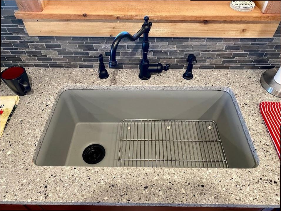 A new black bridge faucet and undermount sink installed by Sergio and Sons Plumbing in a Tulsa kitchen.